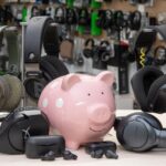 Bluetooth headphones shopping concept with piggy bank and audio gear representing budget buying options